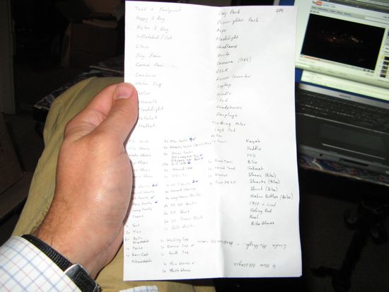 My hand, posing with my handwritten packing list.